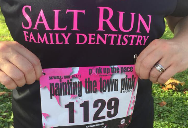 Salt Run Family Dentistry team member holding up race number at fun run