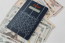 Calculator and cash on white background