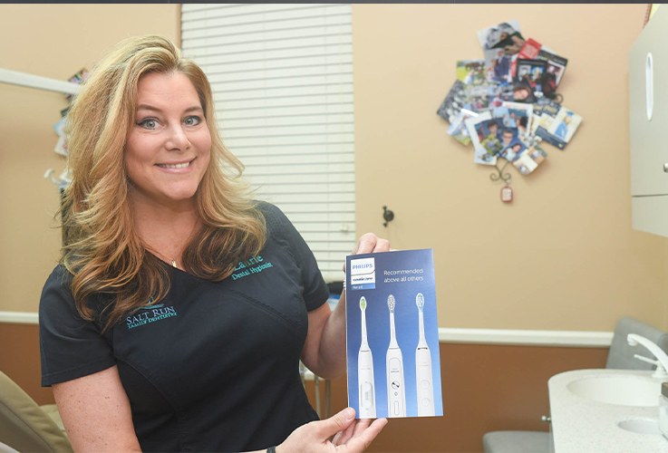 Dental team member holding a brochure for an electric toothbrush