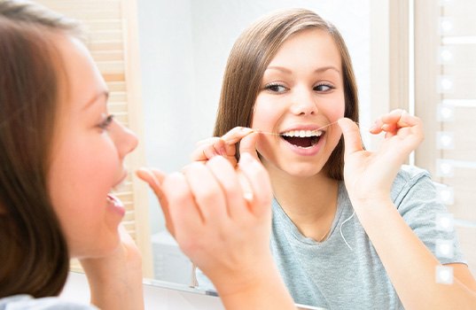 Woman flossing her teeth