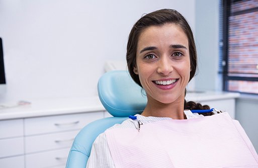 Woman sitting in dental chair smiling