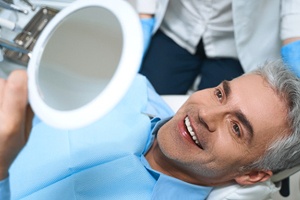 Man admiring his smile after cosmetic dentistry in St. Augustine