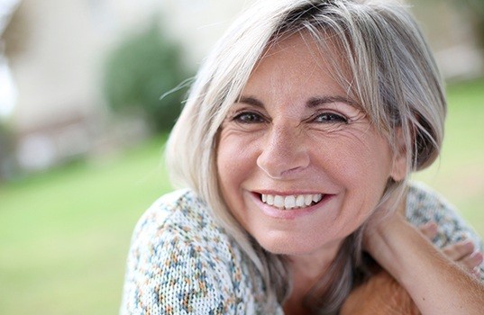 Woman smiling after dental implant tooth replacement