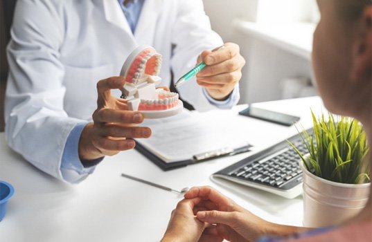 a dentist explaining how dentures are made in St. Augustine