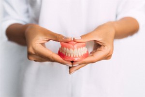 a person holding a pair of dentures in St. Augustine