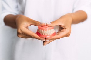 a person holding a pair of dentures in St. Augustine 