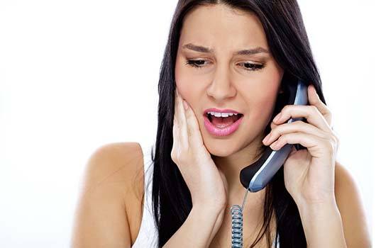 Woman with toothache calling her St. Augustine emergency dentist