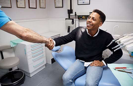 dentist and patient shake over cost of dental emergencies in St. Augustine