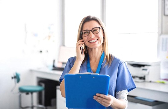 smiling dental team member talking on the phone