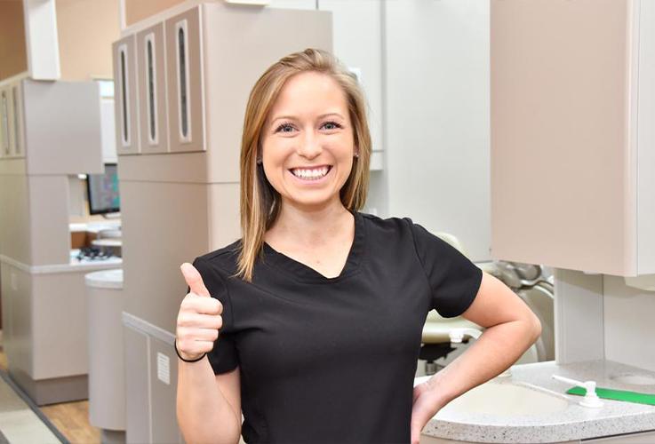 Smiling dental team member giving thumbs up