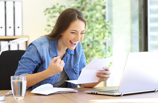 Woman celebrating at her desk after seeing her Humana benefits