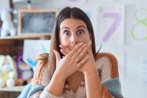 Woman with knocked out tooth covering mouth