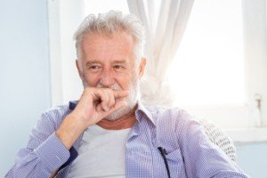 Man with lost filling covering mouth