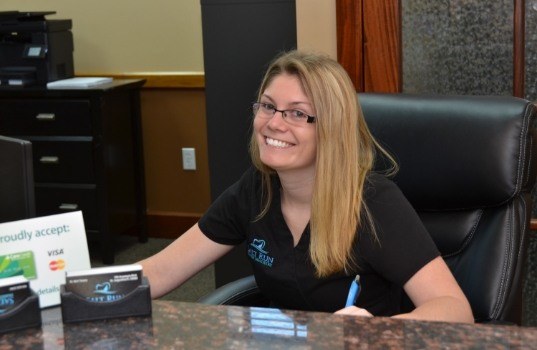 Smiling dental team member at front desk