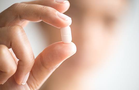Patient holding oral conscious sedation dentistry pill