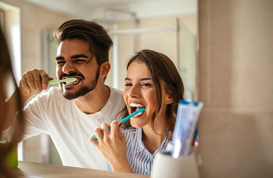 Man and woman  brushing teeth together