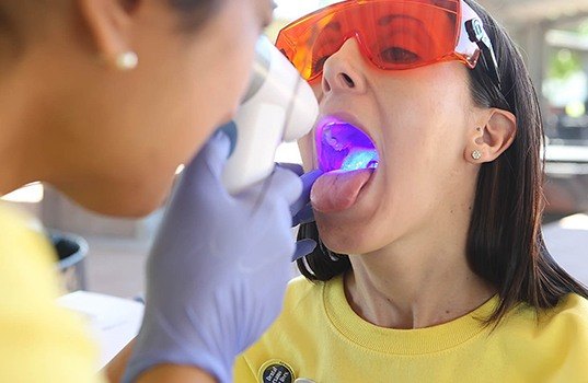 dentist performing oral cancer screening