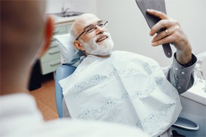 a patient checking his dental implants with a mirror