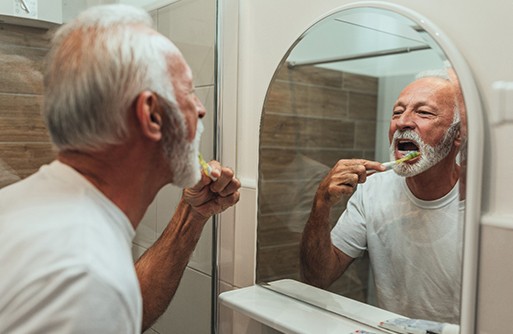 man brushing his dental implants in St. Augustine 