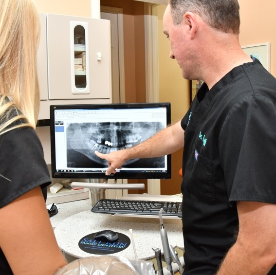 Dentist and dental team member looking at digital dental x rays