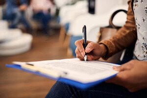 woman filling out dental insurance form in lobby