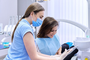dental assistant reviewing cost with smiling patient