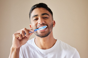 Man in white shirt brushing teeth