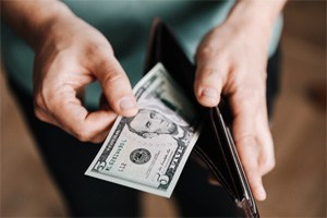 Man looking at cash in wallet