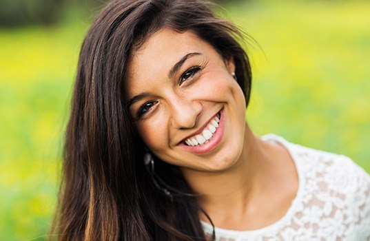 Woman smiling after porcelain veneer placement