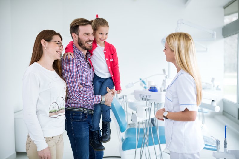 Dentist talking to family at routine appointment