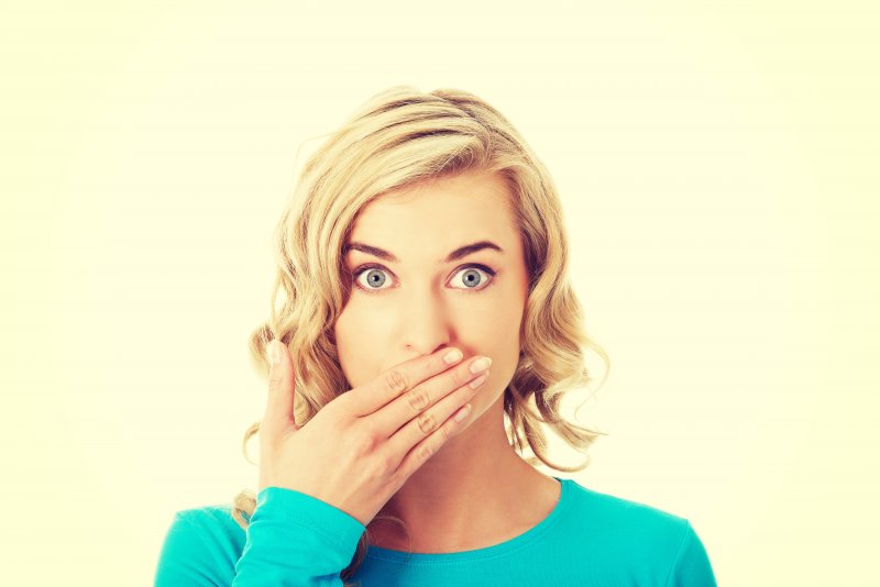 Woman with tooth sensitivity covering her mouth