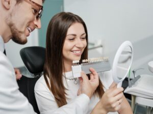 Young woman looking at dentures at doctor's office. 