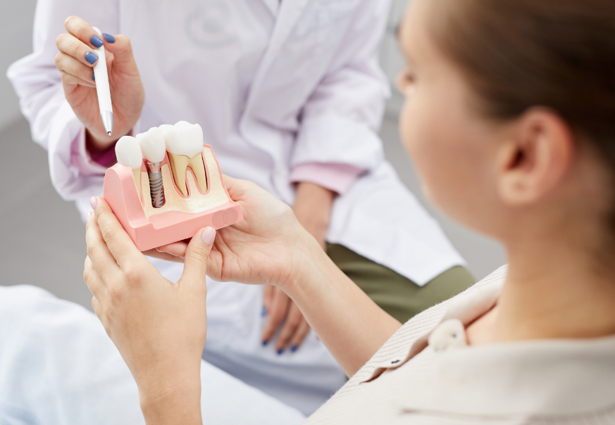 Dentist showing patient dental implant mold