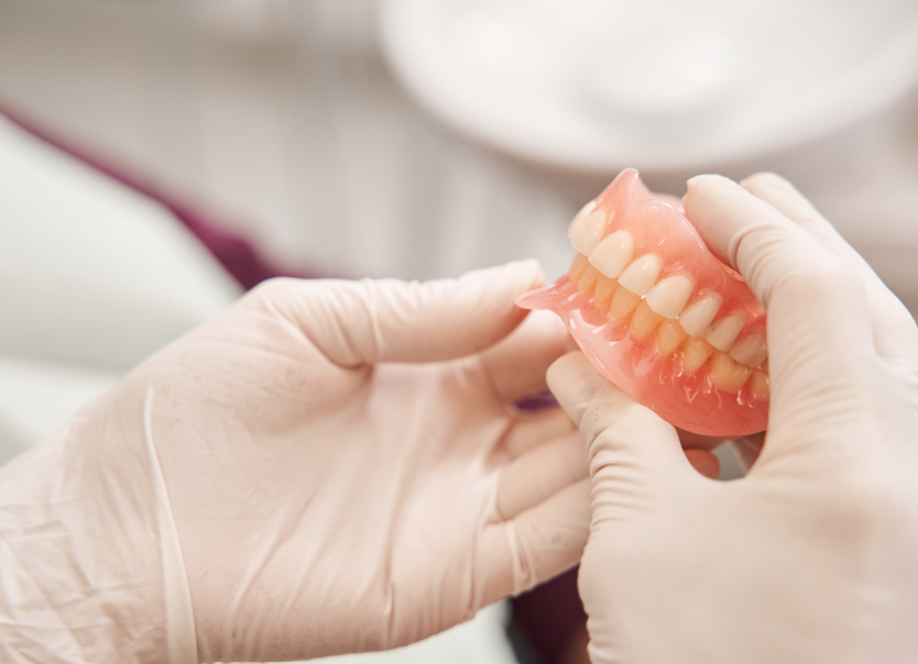 Dentist holding dentures