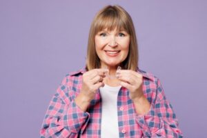 Older woman putting on her Invisalign