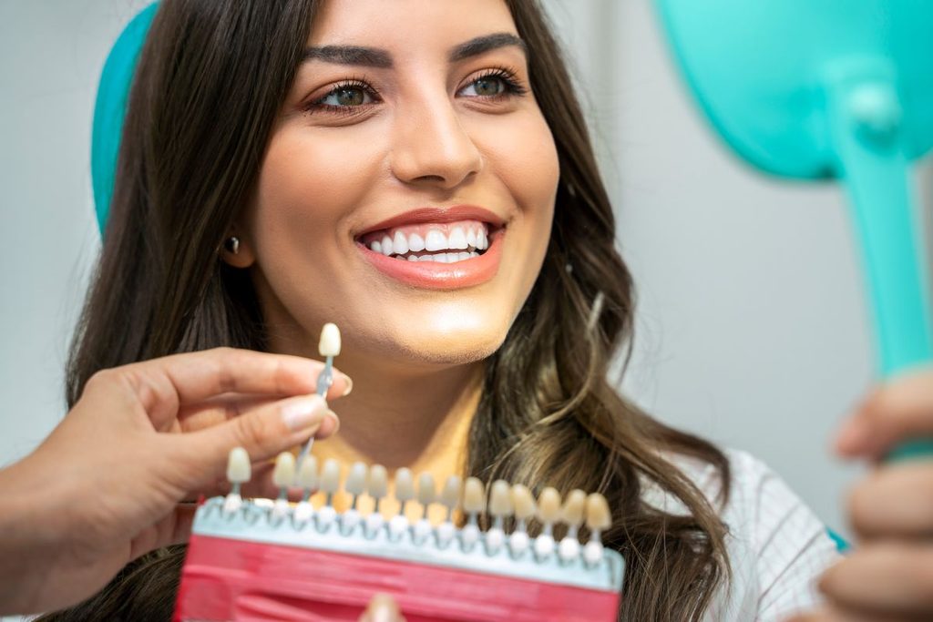 A woman getting teeth whitening treatment from a dentist